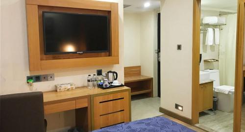 a room with a desk with a flat screen tv at Days Hotel Dhaka in Dhaka