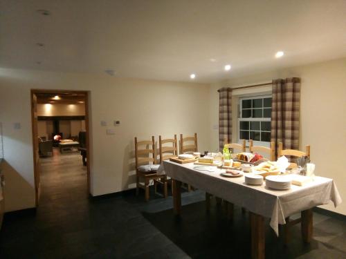 Pershbrook Cottage & Garden في Oakle Street: غرفة طعام مع طاولة بيضاء وكراسي