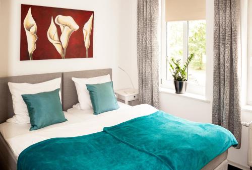 um quarto com uma cama com lençóis azuis e uma janela em Tarata Wohnung em Halle an der Saale