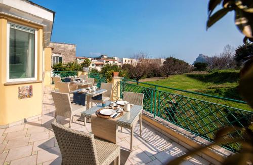 a patio with tables and chairs on a balcony at B&B Marcantonio - Ischia Ponte in Ischia