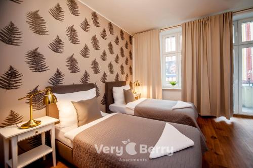 een hotelkamer met 2 bedden en een muur met bladeren bij Very Berry - Sniadeckich 1 - Fair Trade Apartments, check in 24h in Poznań