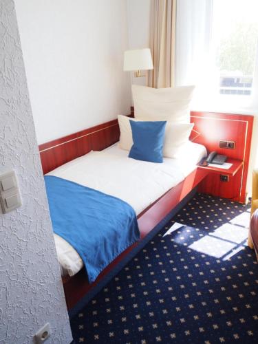 a small bed in a room with a window at Hotel Meeresruh Garni in Cuxhaven