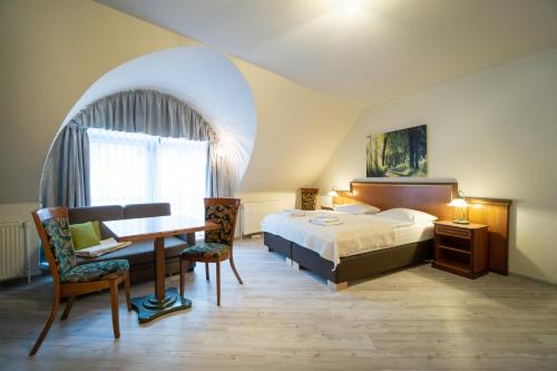 a bedroom with a bed and a desk and a table at Stadt Aparthaus in Waren
