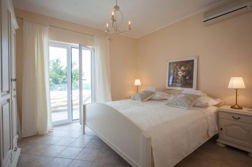 a bedroom with a large white bed and a window at Villa Retro fusion a luxury villa in Tucepi in Tučepi