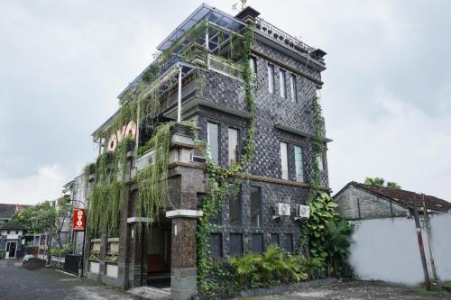 an old building with ivy on the side of it at OYO 444 Rafitha Homestay in Yogyakarta