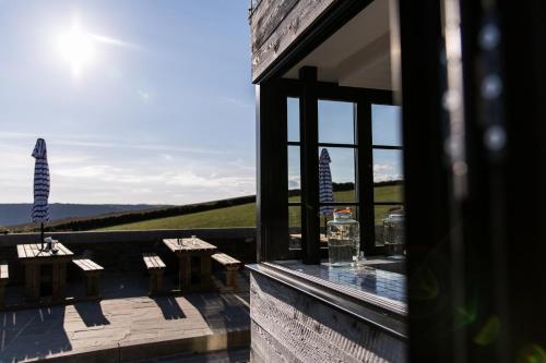 a balcony with tables and a view of the ocean at Gara Rock in Salcombe