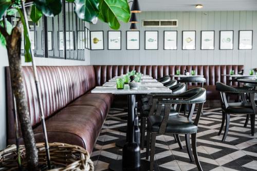 a restaurant with a leather couch and tables and chairs at Gara Rock in Salcombe