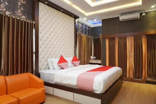 a bedroom with a bed and an orange chair at Super OYO 444 Rafitha Homestay in Yogyakarta