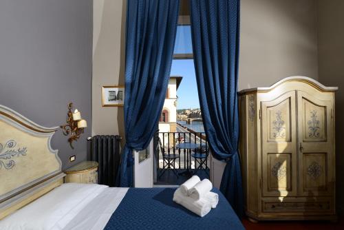a bedroom with a bed and a window with blue curtains at Residenza Vespucci in Florence