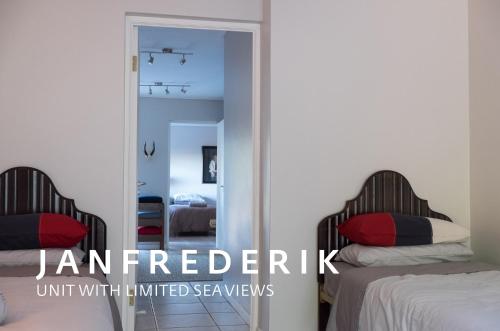 a bedroom with two beds and a mirror at Soutbos & Janfrederik in Agulhas