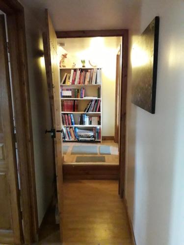 a hallway with a book shelf with books at La Pitardière Gite in Villaines-la-Juhel