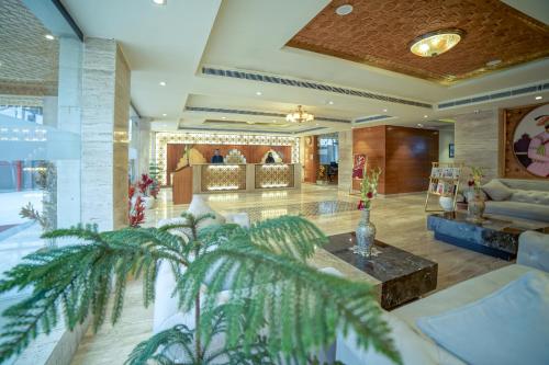 a lobby of a hotel with a palm tree at Regenta Central Srinagar, Rajbagh in Srinagar