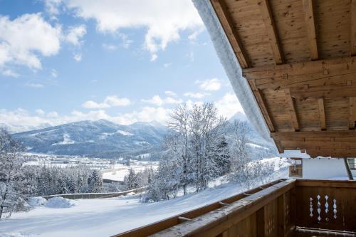 a view from the balcony of a cabin in the snow at Oberschartlhof in Flachau
