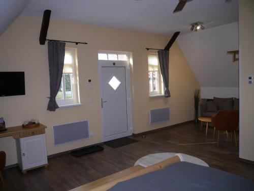 a room with a door and a living room with a couch at Café im Hof- Bed & Breakfast in Streufdorf