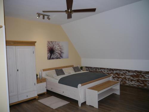 a bedroom with a bed and a ceiling fan at Café im Hof in Streufdorf