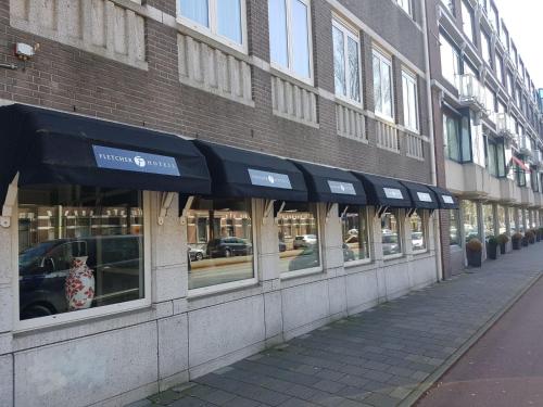 einen Laden mit schwarzer Markise an der Seite eines Gebäudes in der Unterkunft Fletcher Stadshotel Den Haag in Den Haag