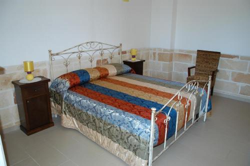 a bedroom with a bed with a colorful blanket on it at Tenuta Annibale in Leverano