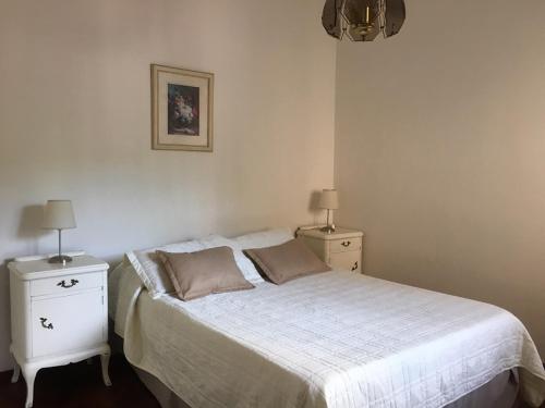 1 dormitorio con 1 cama blanca y 2 mesitas de noche en Mendoza Centrico Departamento Amoblado en Mendoza