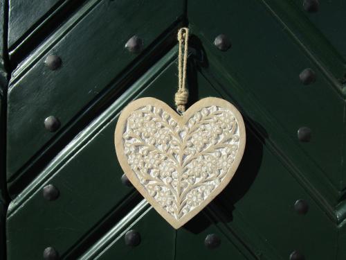 a wooden heart hanging on a green door at Hollwegers Landhaus - Das Lisl in Sankt Gilgen