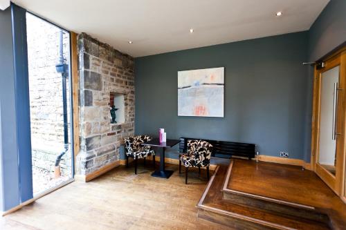 a room with chairs and a table and a brick wall at Best Western Plus Sheffield Mosborough Hall Hotel in Sheffield