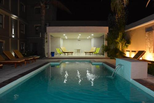 a swimming pool at night with chairs and a table at Mercedes Park Hotel in Villa Mercedes