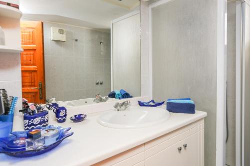 a bathroom with a sink and a mirror at Achladies Beach Apartment in Skiathos