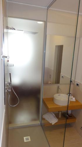 a bathroom with a glass shower with a sink at Portica10 Assisi in Assisi