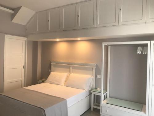 a small bedroom with a white bed and cabinets at Residenza Corallina in Tropea
