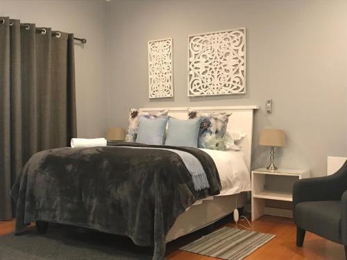 a bedroom with a large bed with blue pillows at Anathi Hotel in Kokstad