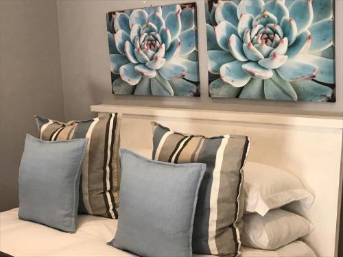 a couch with two pillows and two paintings on the wall at Anathi Hotel in Kokstad