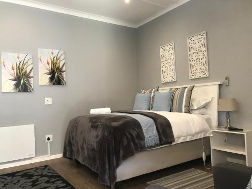 a bedroom with a bed and two paintings on the wall at Anathi Hotel in Kokstad