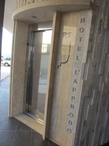 a building with a sign on the side of it at Hotel L'Approdo in Anzio