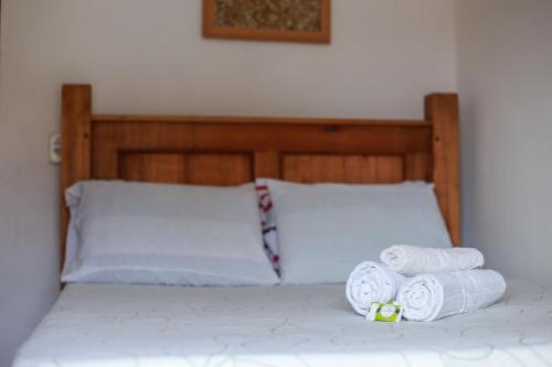 Una cama con tres rollos de toallas. en Pousada e Chalés Itamoara, en São Thomé das Letras