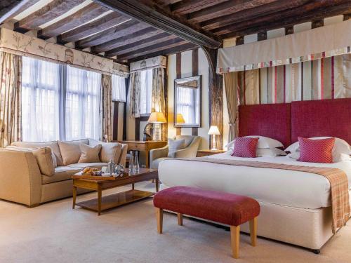 a large bedroom with a large bed and a couch at Swan Hotel & Spa in Lavenham