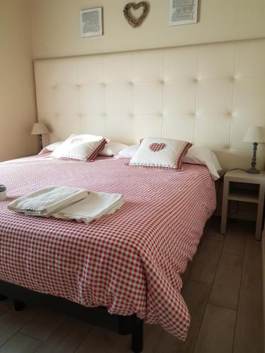 a bedroom with two beds with a red and white blanket at Luna City in Ravenna