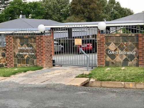 a gate to a brick building with a glass entrance at Anathi Hotel in Kokstad