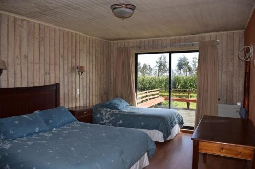 Giường trong phòng chung tại Hotel Cabañas Antulafkén