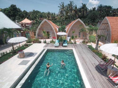 two people in a swimming pool at a resort at La Roja Bungalows in Nusa Penida