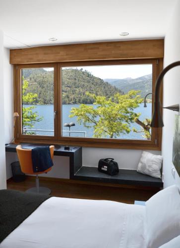 a bedroom with a desk and a large window at Posada del Agua in El Barraco