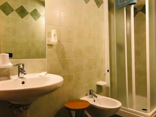 ein Bad mit einem Waschbecken und einer Dusche in der Unterkunft Hotel Santoni in Ossana