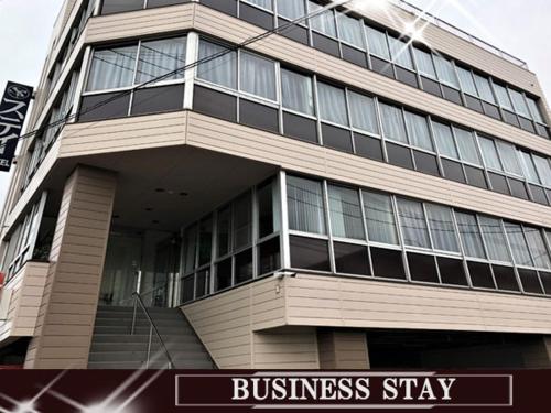 a tall building with a sign in front of it at Business Stay in Satsumasendai
