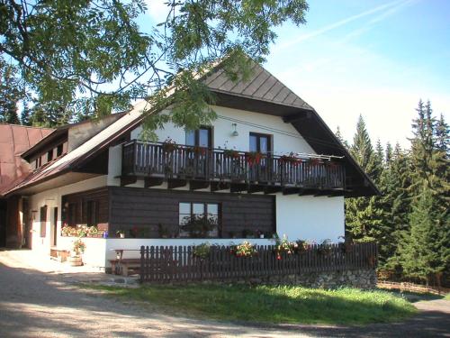 uma casa branca com uma varanda e uma cerca em Chalupa u Pichlerů em Stachy
