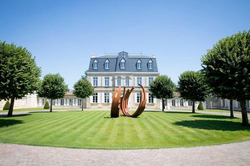 a sculpture in the grass in front of a building at Château Malescasse in Lamarque
