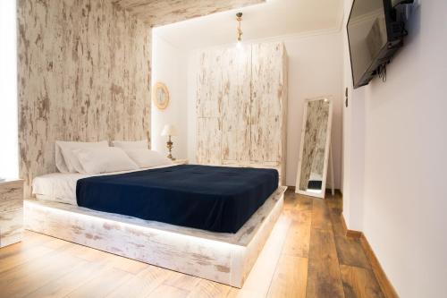 a bedroom with a large bed with a blue blanket at Thess Nature Apartment in Thessaloniki