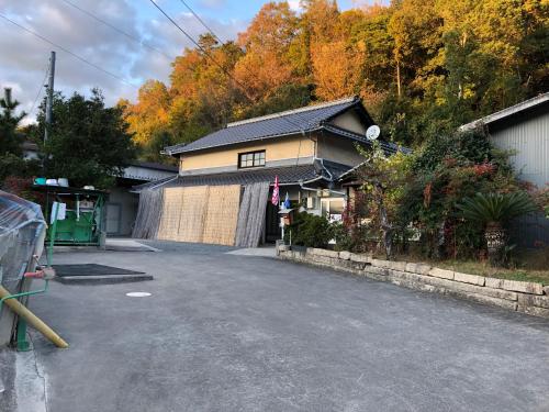 ein Haus am Straßenrand in der Unterkunft Rider & Guest House Kazeyoubi in Fukuyama