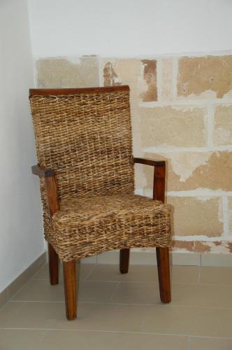 a wicker chair sitting in front of a wall at Tenuta Annibale in Leverano