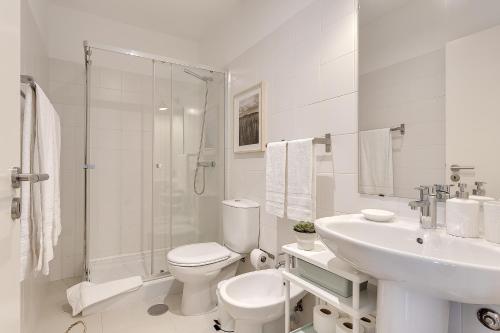 a white bathroom with a toilet and a sink at DA'HOME - Boavista Beautiful Apartment in Porto