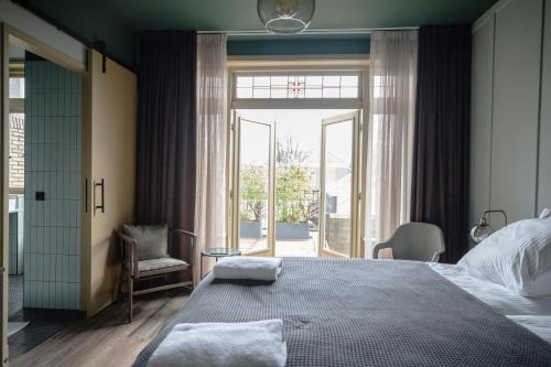 um quarto com uma cama grande e uma janela grande em Mr Lewis Zandvoort em Overveen