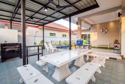 a group of tables and benches in a room at Greenview Pool Villa Cha-am in Cha Am