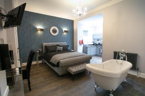 a bedroom with a bed and a tub and a sink at Apartments at Number 82 The Unthank in Norwich